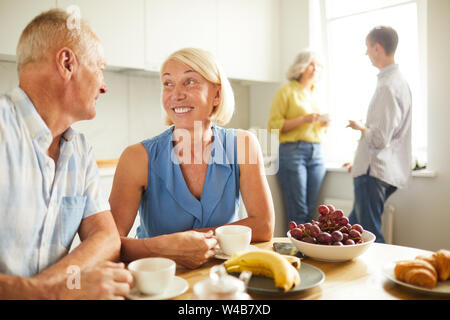 Portrait von glücklich nach Paar an jedem anderen Standort suchen, zärtlich, während am Küchentisch im Sonnenlicht, kopieren Raum Stockfoto