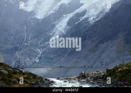 Wanderer auf Hooker Fluss Fußgängerbrücke & Mt Sefton, Aoraki/Mt Cook Nationalpark, Canterbury, Südinsel, Neuseeland Stockfoto