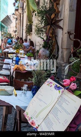 Mittagessen in Ortegia, Siracusa, Sizilien. Das Restaurant hat Tische in der Straße platziert. Gäste können das warme Wetter und die Sonne den ganzen Tag über genießen. Stockfoto