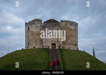 YORK, ENGLAND, 12. Dezember 2018: Rot gekleidet Familie Eingabe der Clifford Tower schloss in der historischen Stadt York Stockfoto