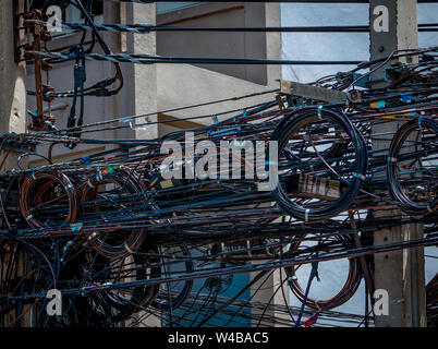 Elektrische Leitungen auf städtische elektrische Pole verheddert. Unorganisiert und chaotisch zu Organisation Management Konzept. Verheddertes Kabel vor Stockfoto