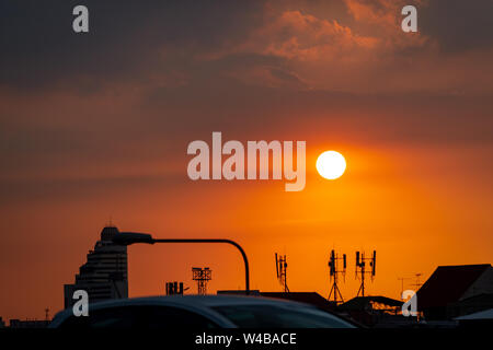 Schönen Sonnenuntergang Himmel über der Stadt. Silhouette Geschäft Gebäude- und Telekommunikations-Turm. Antenne auf Sonnenuntergang Himmel Hintergrund. Radio und Satelliten Stockfoto