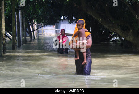 Tangail, Bangladesch. 21. Juli 2019. Frauen bewegen in einer Flut betroffenen Bereich nach schweren Monsunregen zu einem Hochwasser betroffene Fläche in Tangail. Über 1 Mio. Menschen wurden durch die Überschwemmungen durch den Monsun Regen und ausufernden Fluss im Norden, Nordosten und hügeligen Regionen in Bangladesch ausgelöst betroffen. Credit: SOPA Images Limited/Alamy leben Nachrichten Stockfoto