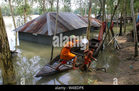 Tangail, Bangladesch. 21. Juli, 2019. Die Menschen nehmen Tierheim neben der Straße nach schweren Monsunregen zu einem Hochwasser betroffene Fläche in Tangail. Über millionen Menschen durch Überschwemmungen durch den Monsun Regen und ausufernden Fluss im Norden, Nordosten und hügeligen Regionen in Bangladesch ausgelöst betroffen. Credit: SOPA Images Limited/Alamy leben Nachrichten Stockfoto