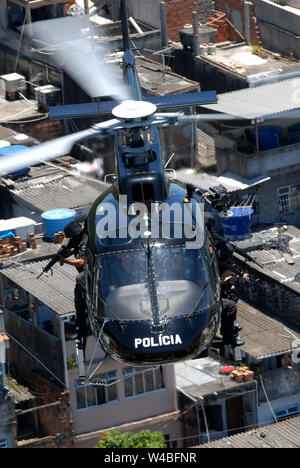 Hubschrauber der zivilen Polizei von Rio de Janeiro, fliegen über Favela während der Konfrontation zwischen der Polizei und den Drogenhändlern in Gemeinschaft in Rio de J Stockfoto