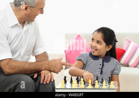 Indische Alter Mann spielt Schach mit seiner Enkelin zu Hause Stockfoto