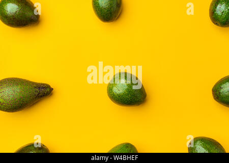 Organische Avocados ganze Früchte auf gelb Tabelle Hintergrund. gesund Super Foods für Ernährung. Frisches Gemüse vom Bauernhof. keto Lebensmittelzutaten. Ausrichtung in Patt Stockfoto