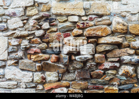 Textur der alten Mauer mit verschiedenen Steinen bedeckt Stockfoto