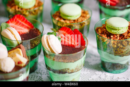 Kleinigkeiten in Kunststoff Gläser mit frischem Obst und Sahne. Stockfoto
