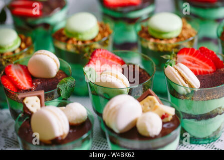 Kleinigkeiten in Kunststoff Gläser mit frischem Obst und Sahne. Stockfoto