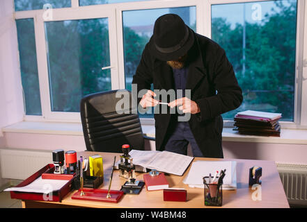 Konzept. Spion nimmt auf dem Foto Dokumente. Dieb im Büro. Stockfoto