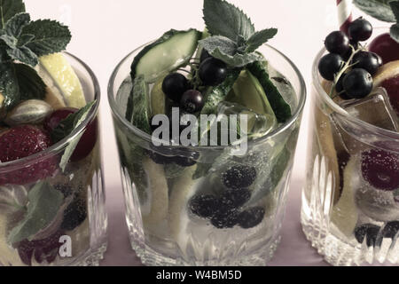 Sommer erfrischende Cocktail aus natürlichen Früchten und verschiedenen Beeren mit Eis und Minze mit Wasser aufgegossen. Enthält Zitrone, Orange, Erdbeere, Cher Stockfoto