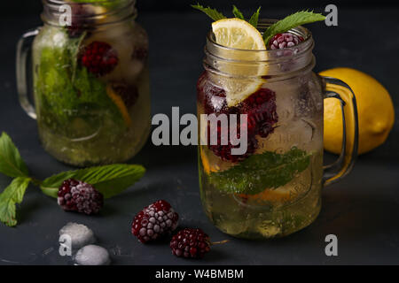 Hausgemachte Limonade mit Zitrone, Blackberry und Minze im Glas vor einem dunklen Hintergrund, horizontale Foto, close-up Stockfoto