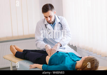 Der Arzt untersucht den Patienten auf dem Tisch. Stockfoto