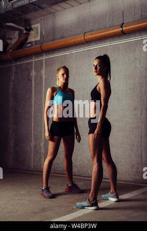 Porträt von zwei Athleten Frauen in Leer stehende Garage Stockfoto