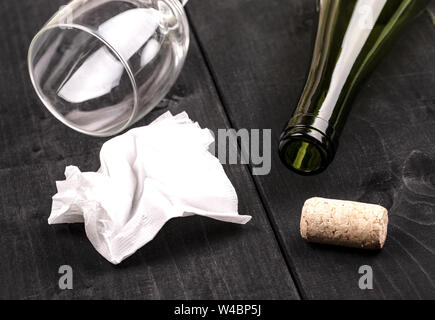 Die weissen zerknittertes Papier Serviette und eine leere Weinflasche mit Kork auf alten Holztisch Stockfoto