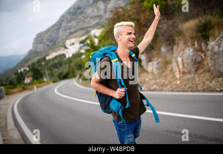 Reisen Mann backpacking per Anhalter auf Straße Reise hitching eine Fahrt aus dem Auto Stockfoto