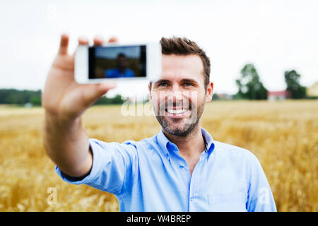 Glückliche Menschen, die selfie in einem Feld Stockfoto