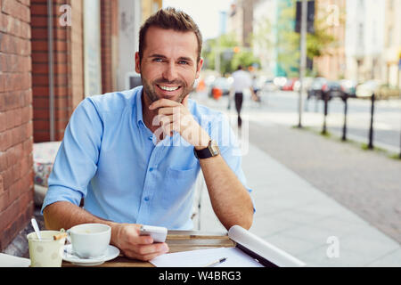 Sommer in der Stadt, jungen Mann, der Kaffeepause im Cafe im Freien Stockfoto