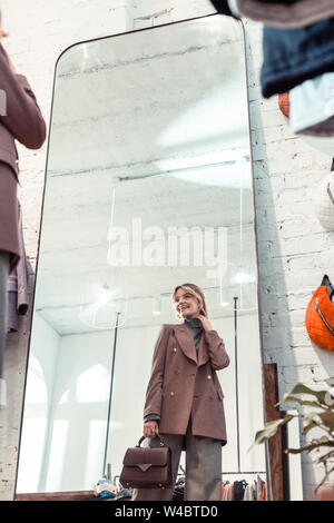 Blonde Frau tragen stilvolle Jacke in Kleidung Boutique Stockfoto