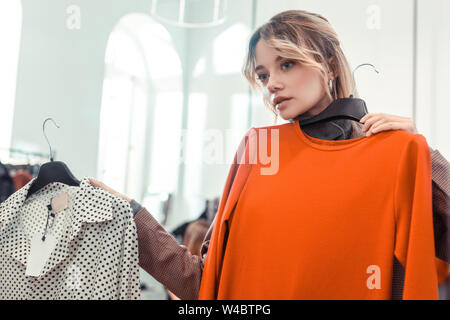 Blonde Frau Gefühl nachdenklich, während sie Kleid Stockfoto