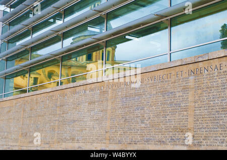 Rom, Italien, 27. Oktober 2017: Reflexion von der alten Kirche von San Rocco auf eine Glaswand des Museo dell'Ara Pacis an einem bewölkten Tag. - Bild Stockfoto