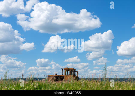 Landwirtschaftliche Maschinen im Vordergrund. Traktoren auf dem Feld in der russischen Dorf, an einem sonnigen Tag und blauer Himmel. Russland. Tatarstan. 6 Jun Stockfoto