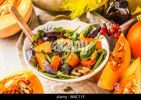 Herbst Salat aus gebackenen Kürbis, Mangold, Zucchini und Karotten. Gesunde vegane Ernährung Konzept. Herbst essen Konzept. Stockfoto