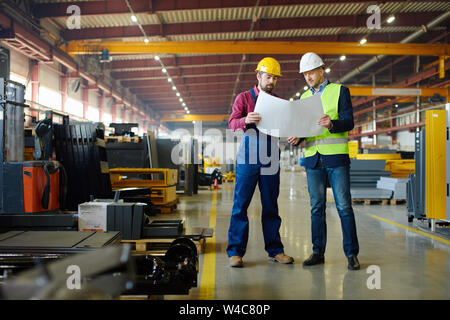 Ingenieure in der harten Hüte auf ein Konzept der industriellen Anlage arbeiten. Stockfoto