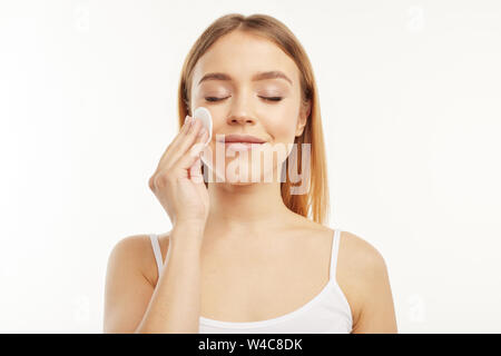 Blonde Mädchen wischte ihr Make-up mit einem Wattepad. Stockfoto