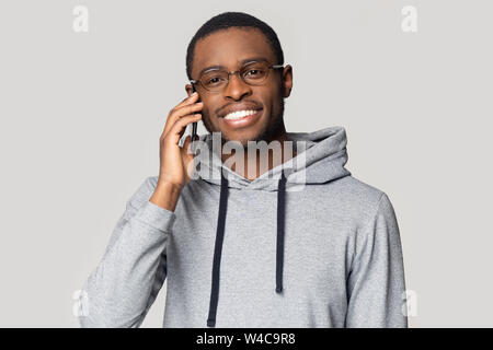 Lächelnd African American Kerl in hoodie Gespräch auf dem Handy Stockfoto