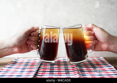 Close-up zwei Hände sind klirren Gläser kaltes Getränk. Stockfoto