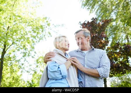 Low Angle Portrait von Happy senior Paar sich einander mit der Liebe beim Gehen im Sommer Park, Kopie Raum Stockfoto