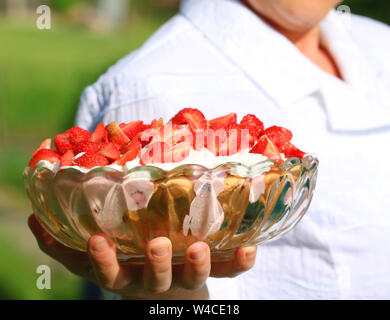 Frau serviert köstliche Erdbeere Dessert Stockfoto