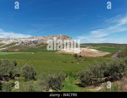 Der Torcal Alto Ridgeline aus dem Hügel Farmen unten im Tal mit ihren weitläufigen Feldern und Olivenhainen gesehen im Mai. Andalusien, Spanien. Stockfoto