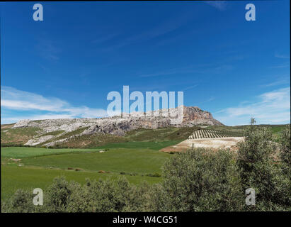 Der Kalkstein Klippen und Berge des Naturparks El Torcal Gebirge mit Blick auf die Hügel von Höfen und Feldern im Tal unten. Andalusien, Spanien. Stockfoto