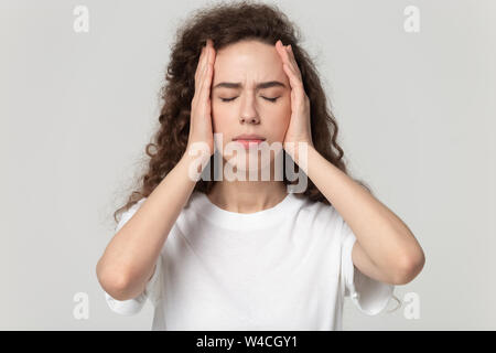 Kopf geschossen Portrait betonte Frau berühren Tempel leidet unter Kopfschmerzen. Stockfoto