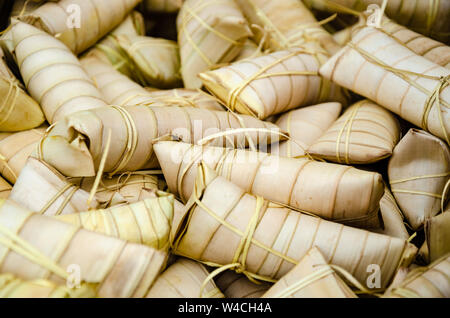 Suman ist ein Filipino Snack oder Dessert und ist ein süsser, Weißer klebriger Reis Kuchen, der in Palm Blätter gewickelt ist und gedämpft. Oft als Straße Lebensmittel verkauft werden, Stockfoto