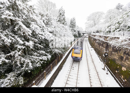 Eine britische Intercity Zug mit Geschwindigkeit reisen auf einem schneebedeckten Titel durch Sydney Gardens, ein Park in Bath, Großbritannien Stockfoto