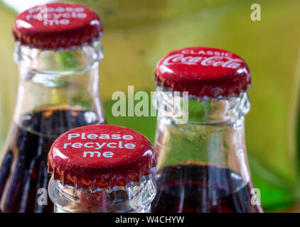 Red Metalle Kappen oben auf Retro Stil Glas Coca Cola Flaschen die Meldung 'Bitte recyceln Sie mich'. Stockfoto