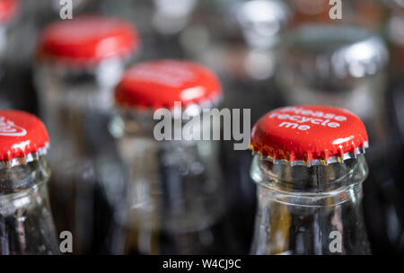 Red Metalle Kappen oben auf Retro Stil Glas Coca Cola Flaschen die Meldung 'Bitte recyceln Sie mich'. Stockfoto