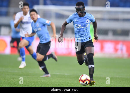 Ghanaischer Fußballspieler Emmanuel Okyere Boateng, rechts, von Dalian Yifang F.C. hält den Ball in der 19. Runde der Chinese Football Association Super League (CSL) gegen Tianjin TEDA in Tianjin, China, 20. Juli 2019. Das Match endete mit einem Unentschieden 3-3. Stockfoto