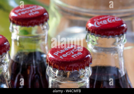 Red Metalle Kappen oben auf Retro Stil Glas Coca Cola Flaschen die Meldung 'Bitte recyceln Sie mich'. Stockfoto