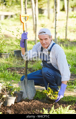 Volle Länge Portrait von reifer Mann im Garten arbeiten und Suchen an Kamera, kopieren Raum Stockfoto