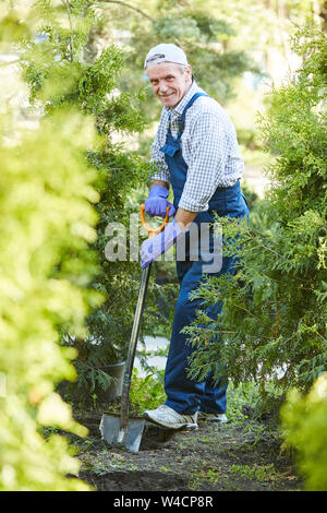 Volle Länge Portrait von lächelnden reifer Mann arbeiten im Garten und auf der Suche an Kamera Stockfoto