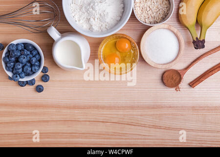 Zutaten für blueberry muffins Vorbereitung auf Holztisch, Ansicht von oben. Backvorgang. Stockfoto