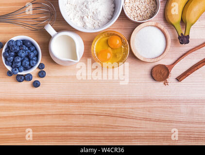 Zutaten für blueberry muffins Vorbereitung auf Holztisch, Ansicht von oben. Backvorgang. Stockfoto