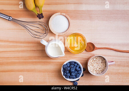 Zutaten für blueberry muffins Vorbereitung auf Holztisch, Ansicht von oben. Backvorgang. Stockfoto