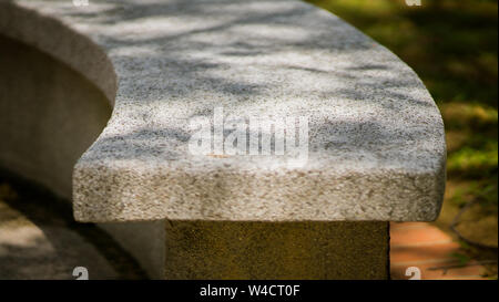 Steinbank mit Pebble Waschen im Freien Park bedeckt. Stockfoto