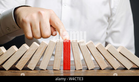 Unternehmer hält Zusammenbruch domino Effekt. Stressresistenz. Die finanzielle Stabilität. Erholung business. Bewertung der Risiken. Erstellen einer Str Stockfoto